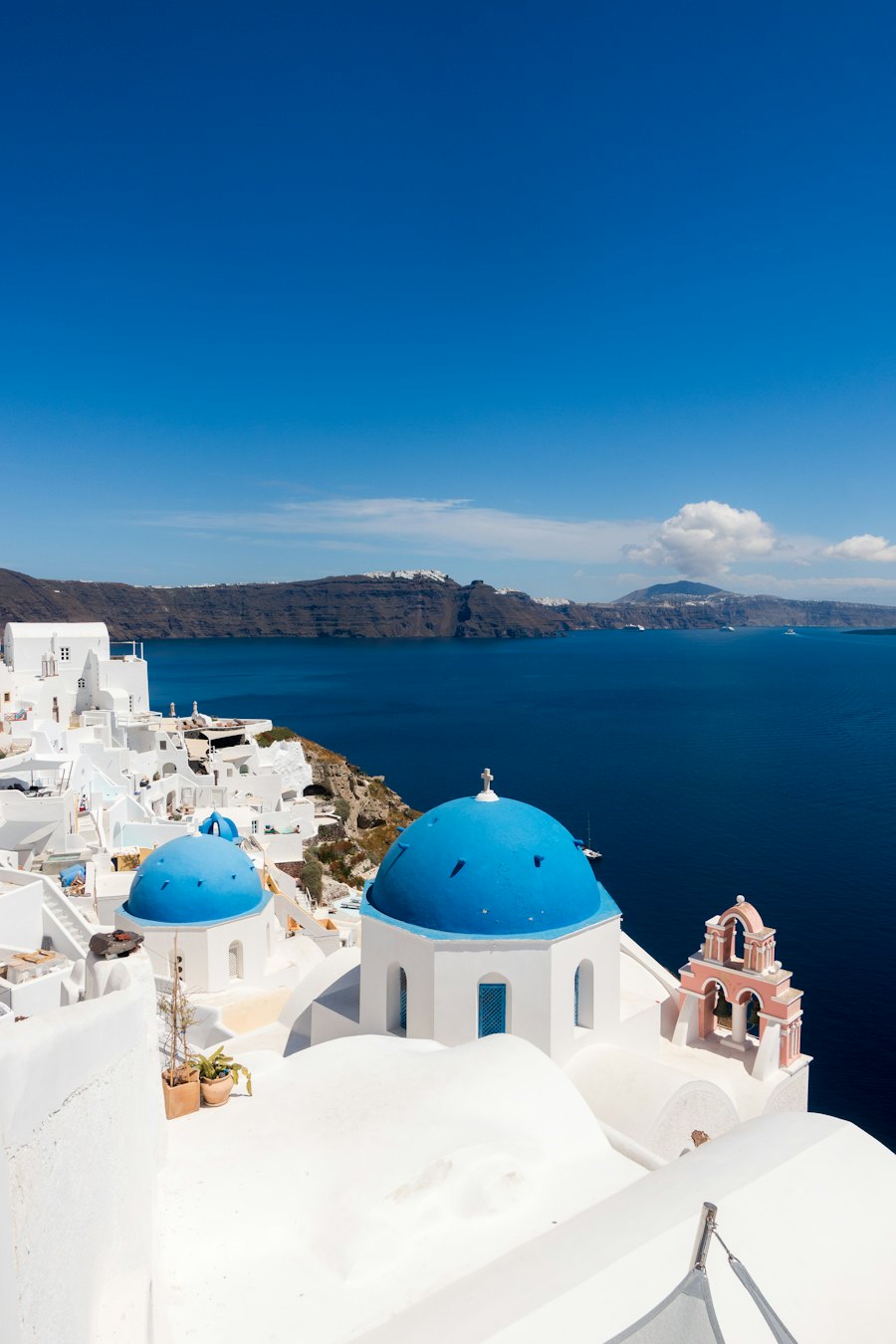 Cúpulas azules y casas blancas junto al mar en Santorini