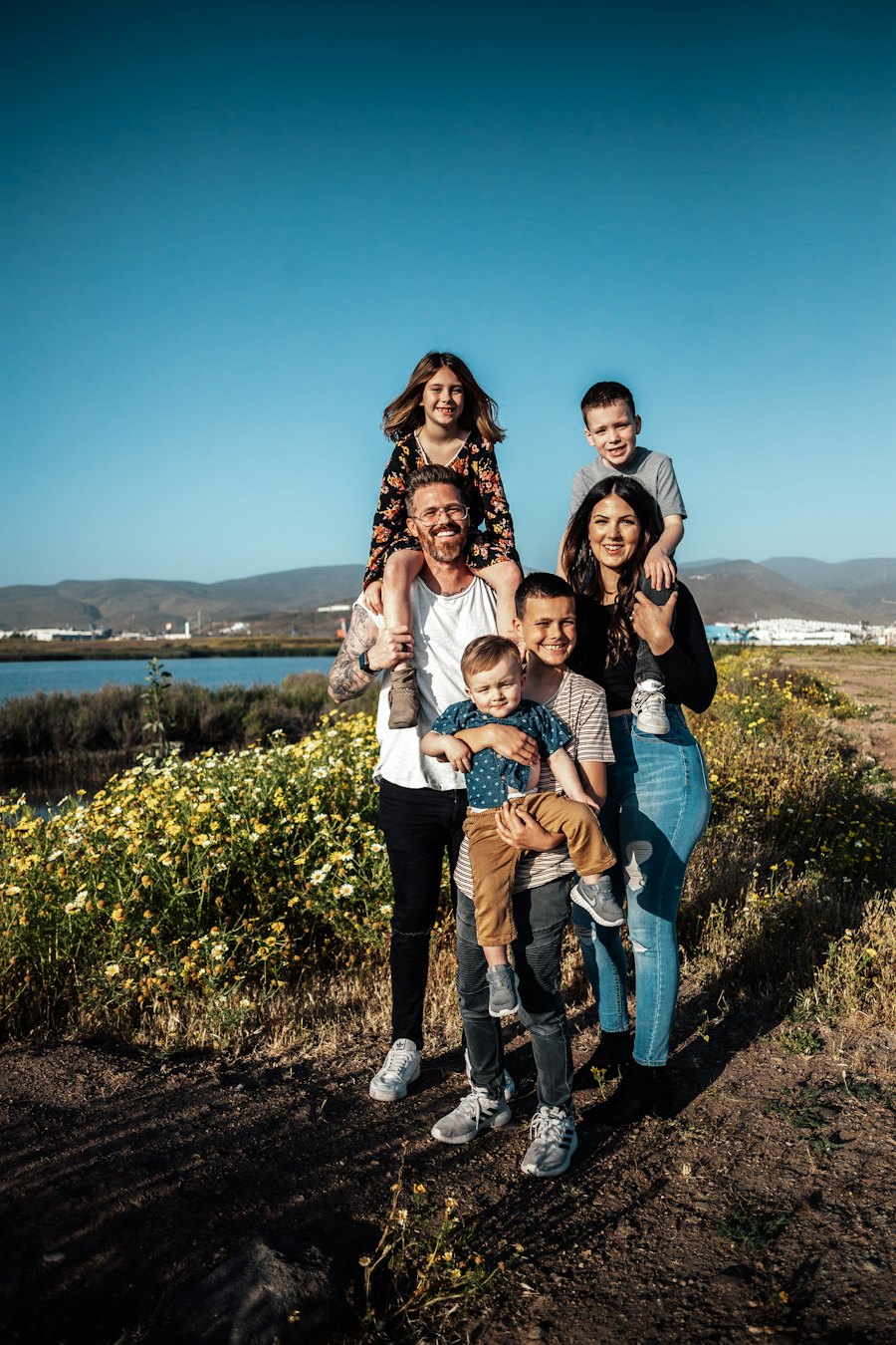 Familia sonriente con niños pequeños disfrutando de un día de viaje